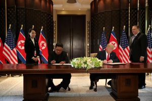 U.S. President Donald Trump and North Korea's leader Kim Jong Un sign documents, after their summit in Singapore